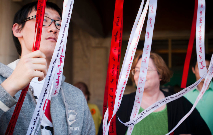 Emory students tying up red and white ribbons in support against violence