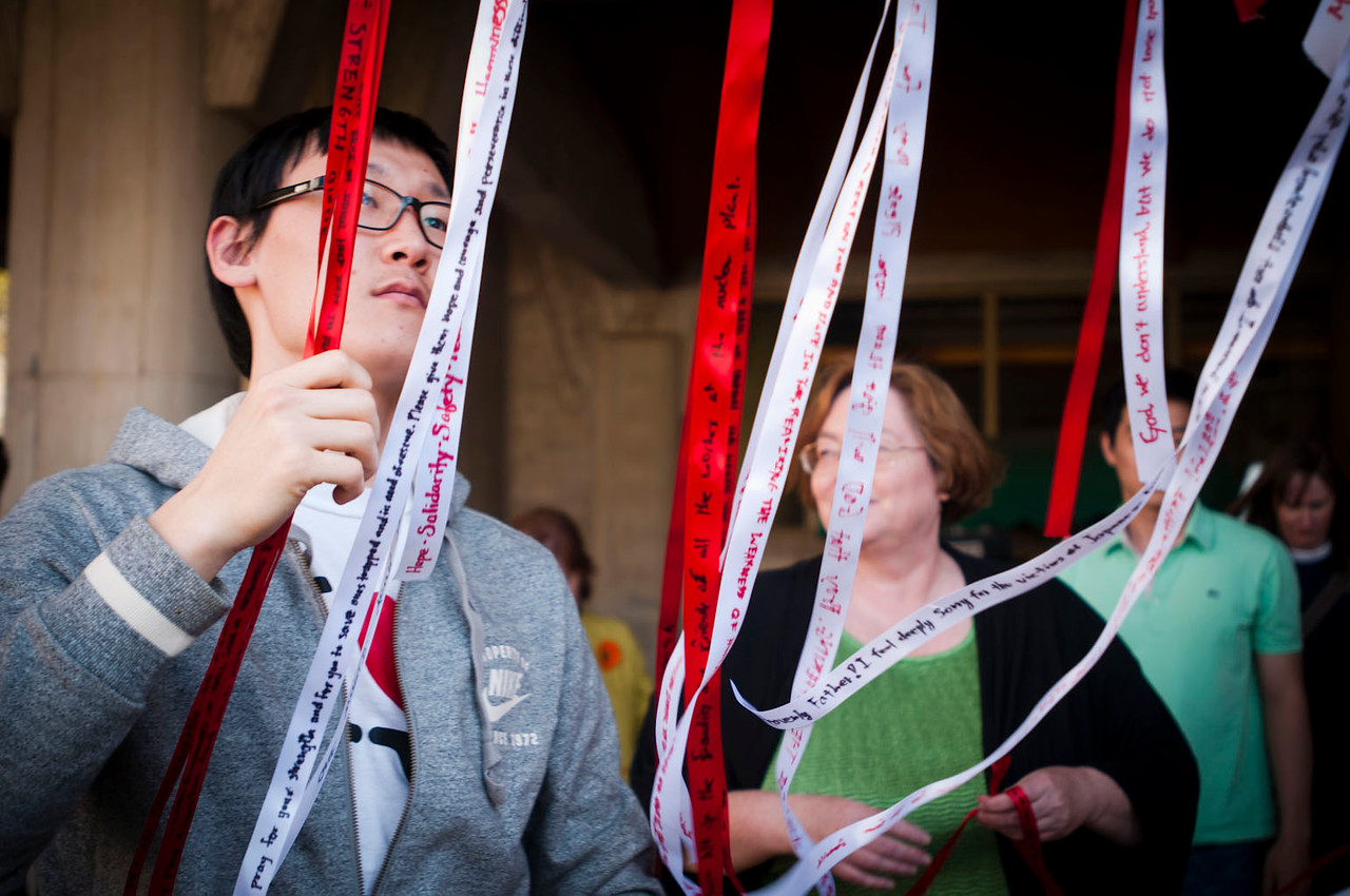 Emory students tying up red and white ribbons in support against violence