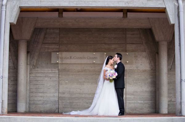 A bride and groom embracing in front of Cannon Chapel